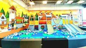 Ein Spielbereich mit Rutschen, Klettergerüsten und einer Ballgrube.
