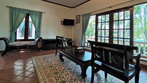 A room with a large window, a ceiling fan, and a television. - Tuna Resort by Zuzu (Rawai)