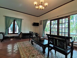 A room with a large window, a ceiling fan, and a television. - Tuna Resort by Zuzu (Rawai)