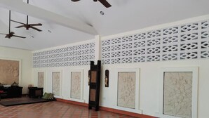A room with a tiled floor, white walls, and a decorative lattice pattern.