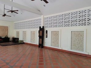A room with a tiled floor, white walls, and a decorative lattice pattern.