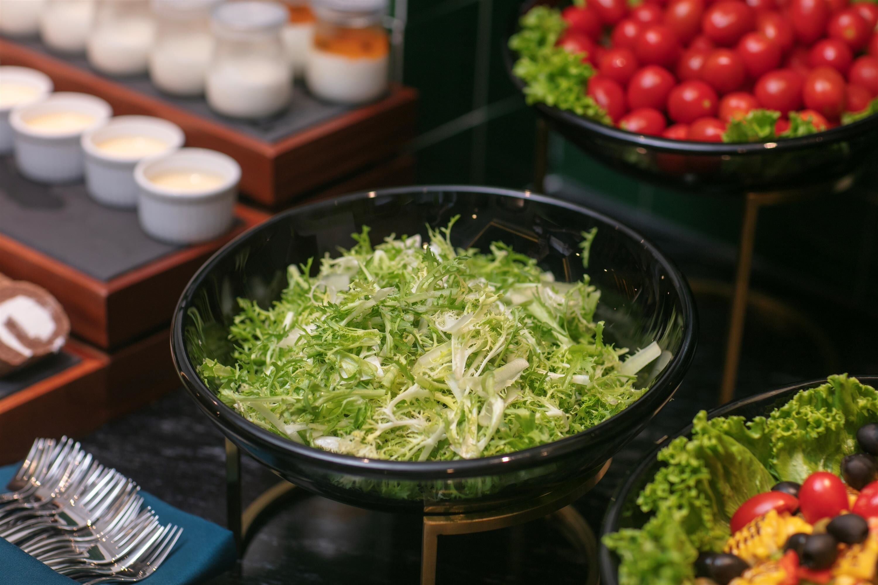 A salad bar with various greens and vegetables.