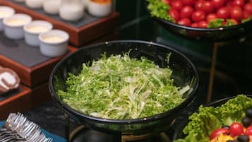 A salad bar with various greens and vegetables.