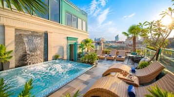Una piscina al aire libre, sombrillas, sillones reclinables de piscina