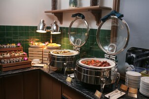 A buffet setup with multiple food stations, including a hot pot and a variety of dishes.