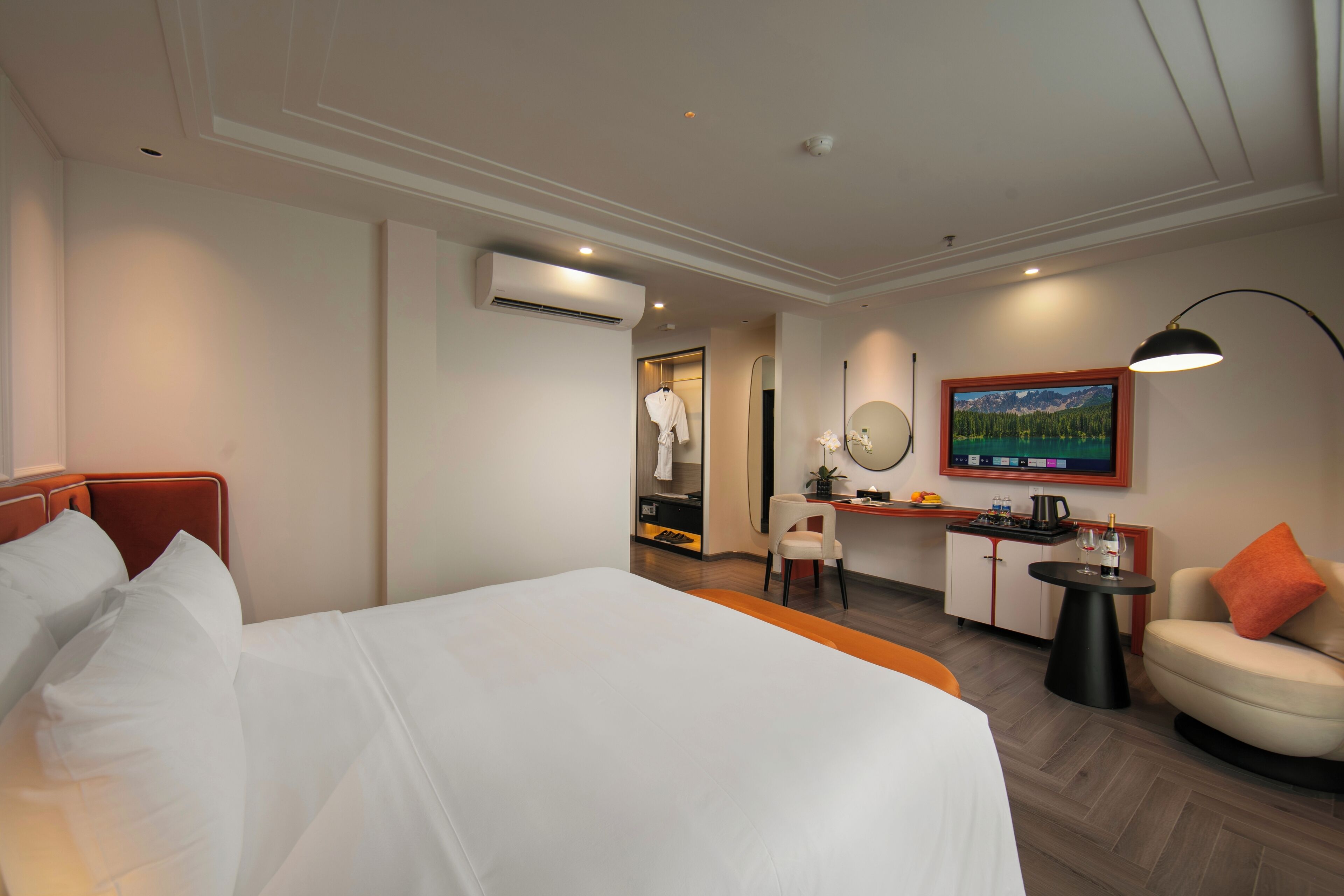 Une chambre d’hôtel équipée d’un lit, d’un bureau, d’une chaise, d’une télévision et d’un miroir.