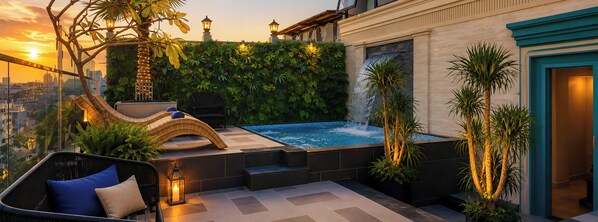 Una terraza en la azotea con un jacuzzi, mobiliario exterior, una fuente de agua y vistas del horizonte de la ciudad.