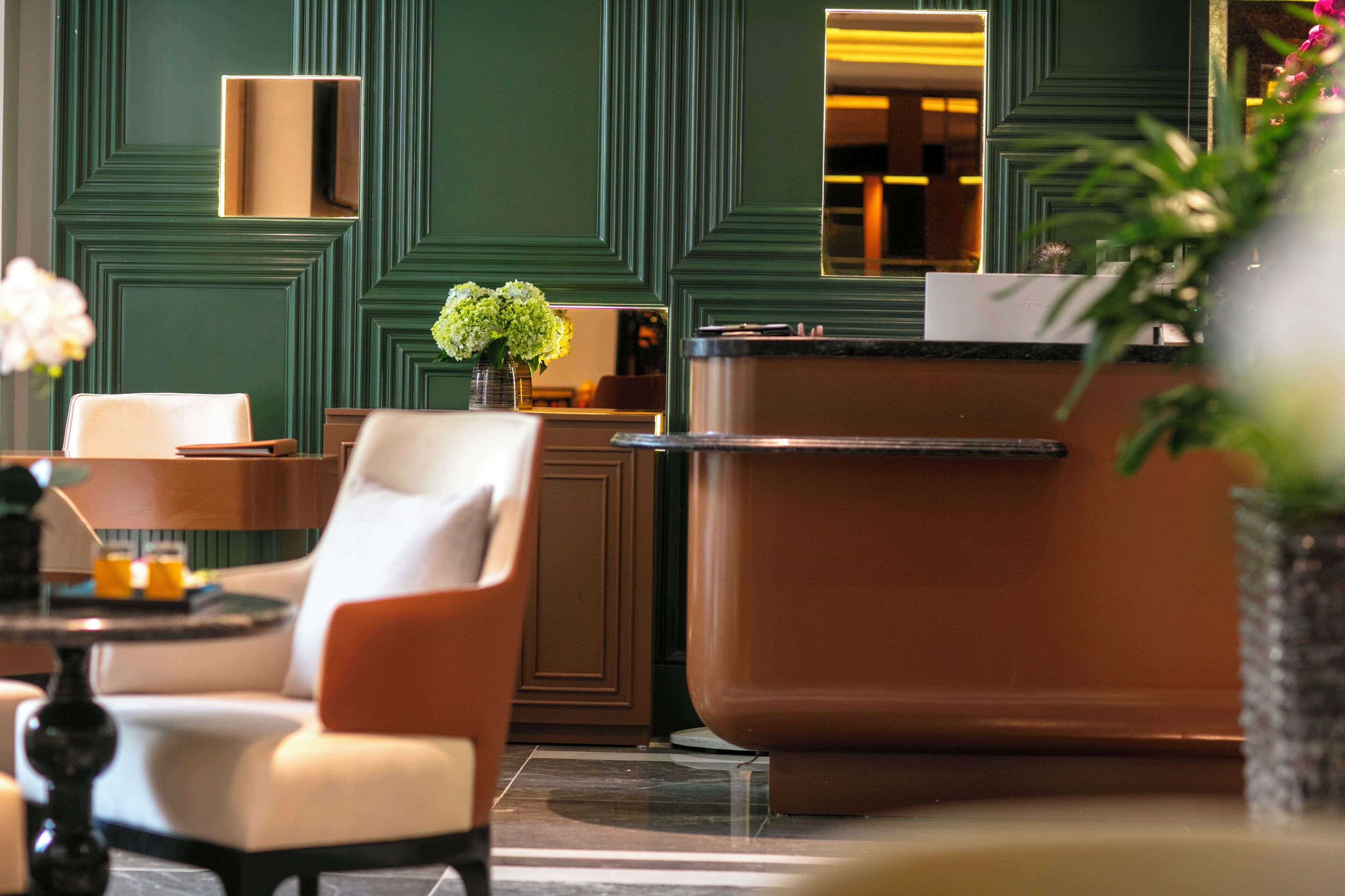 A modern interior with a reception desk, seating area, and decorative elements.