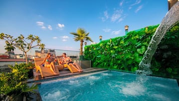 Una piscina al aire libre, sombrillas, sillones reclinables de piscina