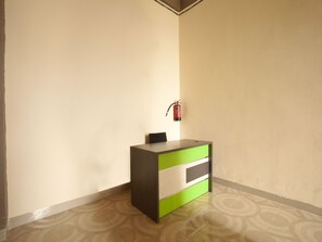 A reception desk with a fire extinguisher mounted on the wall. - Reddoorz Syariah @ Dinda Residence (Medan)
