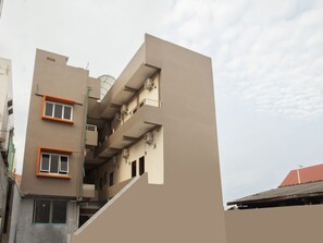 A multi-story building with a flat facade, balconies, and a stairwell. - Reddoorz Syariah @ Dinda Residence (Medan)