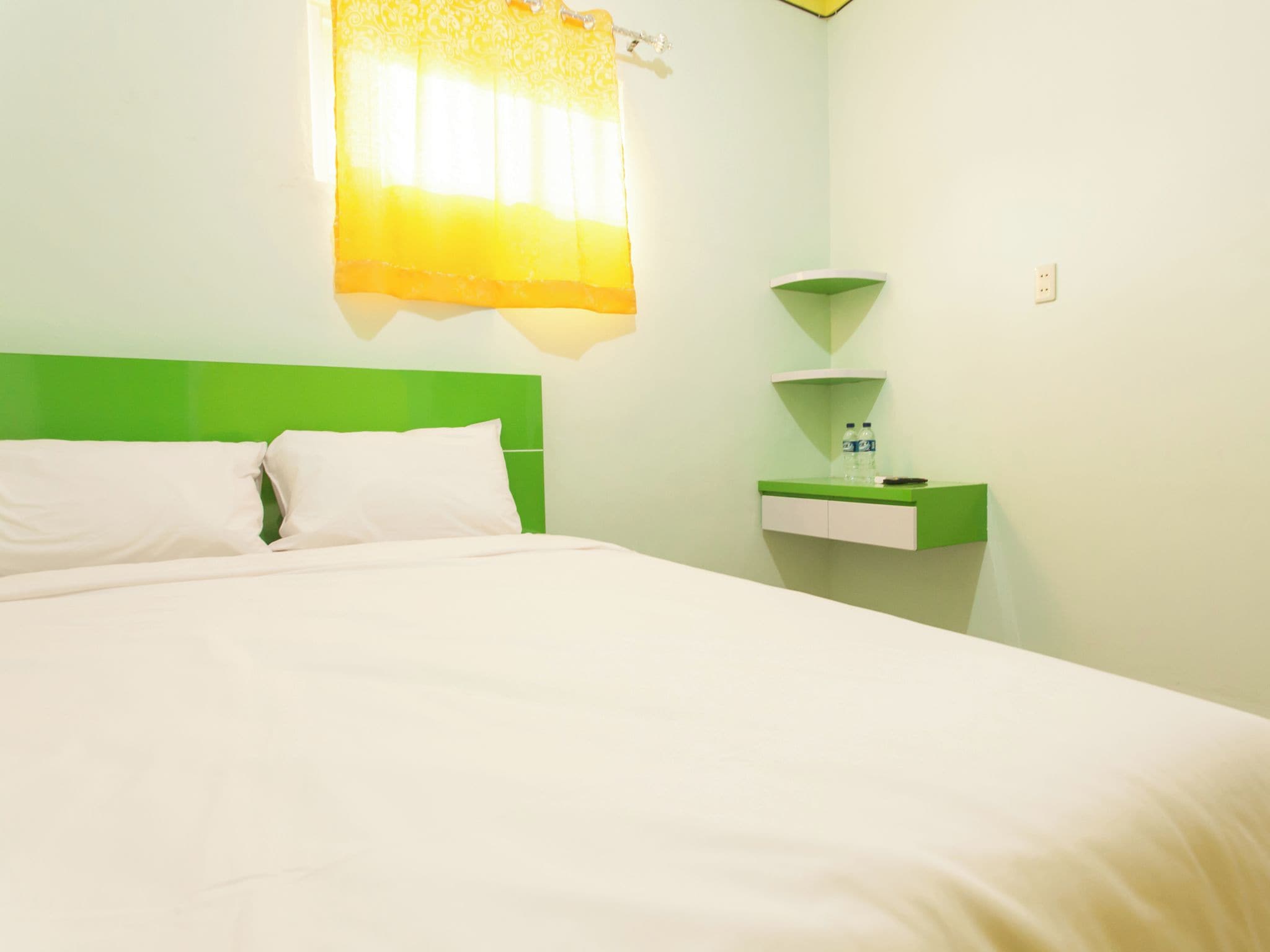 Ein Hotelzimmer mit einem Bett, einem Nachttisch und einer Wandablage.
