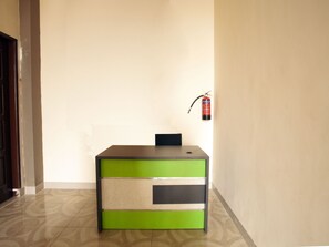 A reception desk with a fire extinguisher mounted on the wall. - Reddoorz Syariah @ Dinda Residence (Medan)
