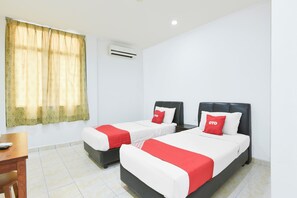 A hotel room with two beds, a desk, and a window with curtains. - Hotel O KB Near Siti Khadijah Market (Kota Bharu)