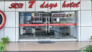 The exterior of KB 7 days hotel with a modern design, glass entrance, and visible signage.