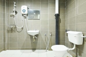 A bathroom with a toilet, sink, and shower.