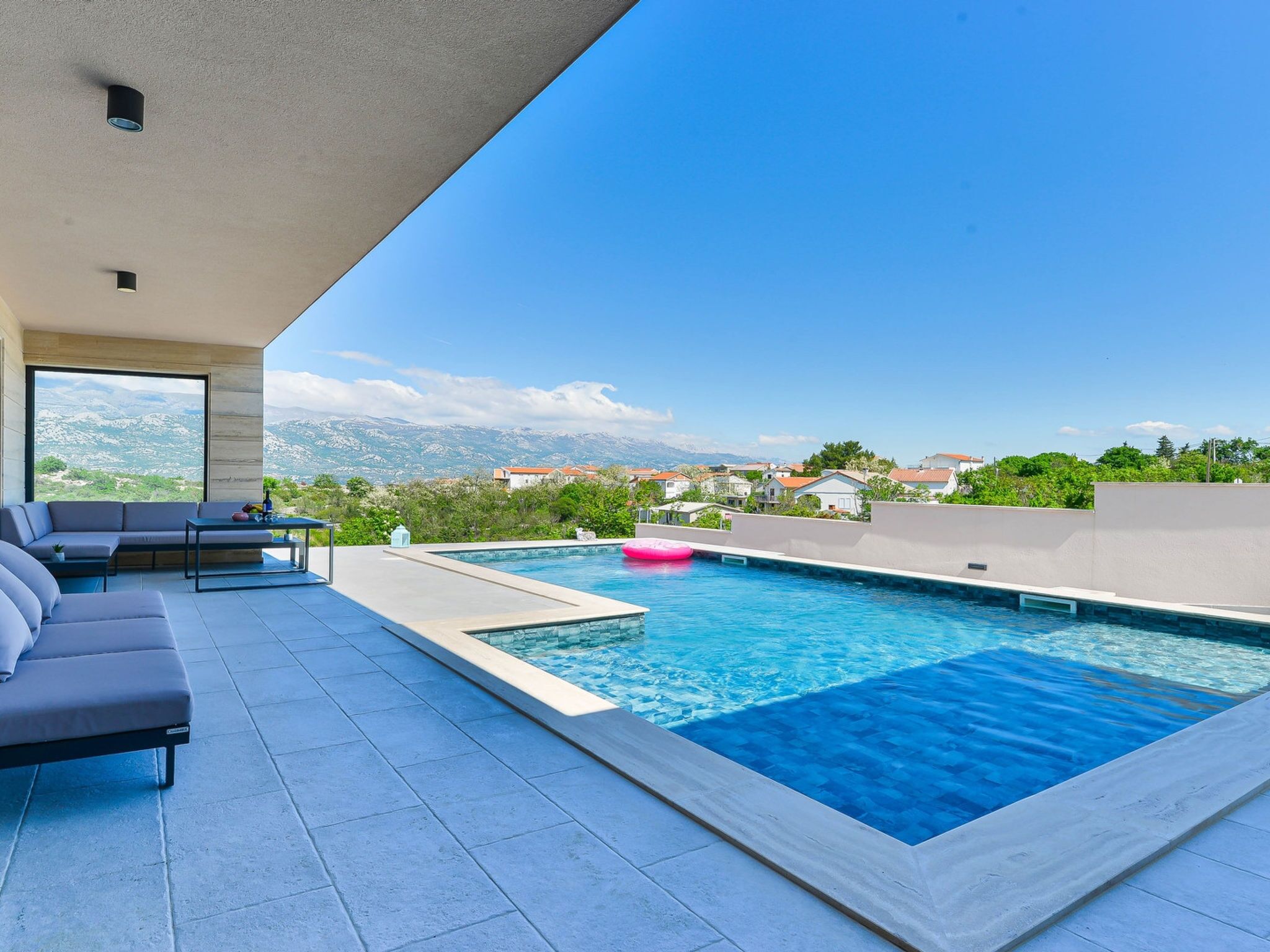 Un espace piscine extérieur moderne offrant une vue sur un paysage montagneux.