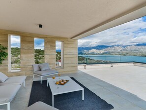 A modern outdoor seating area with a view of mountains and a lake. - Villa Zariva with pool and panoramic mountain and by Interhome (Vinjerac)