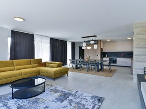 A modern living room with a yellow sofa, a round coffee table, and a dining area with a table and chairs. - Villa Zariva with pool and panoramic mountain and by Interhome (Vinjerac)