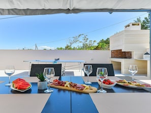 An outdoor dining area with a table set for two, featuring a variety of food and drinks. - Villa Zariva with pool and panoramic mountain and by Interhome (Vinjerac)