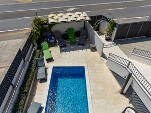 Ein Pool auf dem Dach mit Liegestühlen und einer Lounge-Ecke.