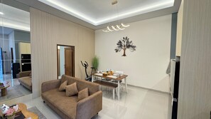 Suite familiar, 2 habitaciones | Área de sala de estar | Televisión LCD de 32 pulgadas con canales por cable 