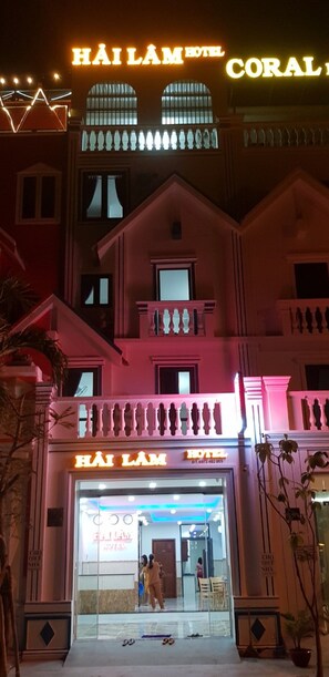 A hotel with a prominent sign reading 'HÀI LÀM HOTEL' and 'CORAL' in illuminated letters. - Hai Lam Hotel (Nha Trang)