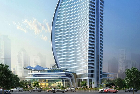 A modern high-rise building with a curved facade, multiple balconies, and a glass entrance. - Wyndham Grand Foshan Gaoming (Foshan)