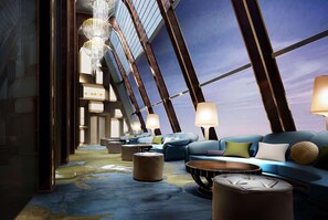 A modern interior with a blue sofa set, round coffee tables, and a chandelier. - Wyndham Grand Foshan Gaoming (Foshan)