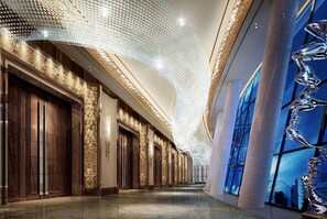 A modern hotel interior with a long corridor, large windows, and a unique ceiling design. - Wyndham Grand Foshan Gaoming (Foshan)