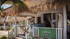 A beachfront property with thatched roofs, wooden deck, and a green banner indicating a certification. - Sudamala Resort, Seraya (Labuan Bajo)