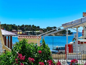 A coastal view with a gas station, a car, and a building with a red roof. - Modern Holiday house Gatsby only 40m from the sea by Interhome (Petrčane)