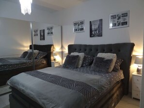 A bedroom with a large bed, two bedside tables, a mirror, and wall art. - Modern Holiday house Gatsby only 40m from the sea by Interhome (Petrčane)