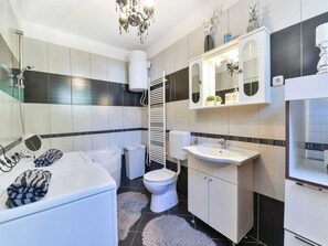 Uma casa de banho moderna com banheira, sanita e lavatório.