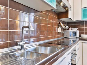 A modern kitchen with stainless steel appliances, a double sink, and a microwave. - Modern Holiday house Gatsby only 40m from the sea by Interhome (Petrčane)
