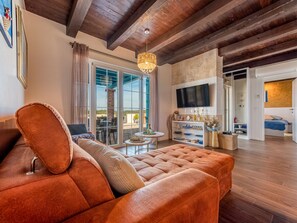 Ein modernes Wohnzimmer mit einem großen Sofa, einem Fernseher und einem Kamin.
