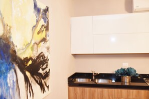 A kitchen with a modern design, featuring a wooden cabinet and a stainless steel sink.