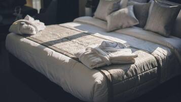 A neatly made bed with pillows and folded towels.