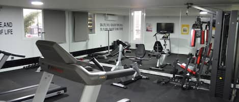 A gym with treadmills, stationary bikes, and weight machines.