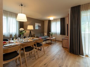 En matplats med ett träbord dukat för två personer, en soffa och ett litet soffbord.