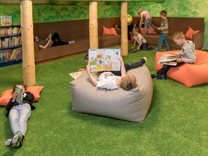 A children's play area with bean bags, books, and a bookshelf.