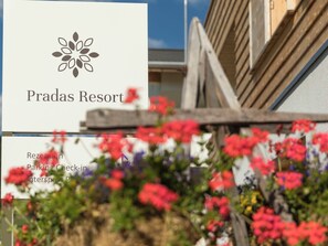 A sign for Pradas Resort with a logo and text indicating parking and check-in information. - Pradas Resort Brigels, (Breil/Brigels), 65055B by Interhome (Breil/Brigels)