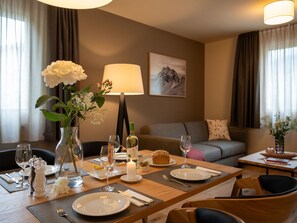 A dining area with a table set for two, including plates, glasses, and a candle. - Pradas Resort Brigels, (Breil/Brigels), 65055B by Interhome (Breil/Brigels)