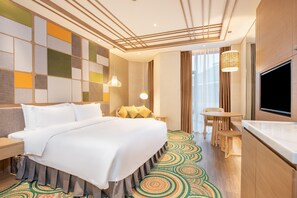 A hotel room with a large bed, a TV, a small table, and a patterned carpet. - Holiday Inn Resort Yichun Mingyue Mountain (Yichun)