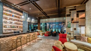 A modern bar area with shelves of bottles, a bar counter, and seating with red cushions. - Holiday Inn Resort Yichun Mingyue Mountain (Yichun)