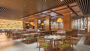 A spacious restaurant with wooden furniture, pendant lighting, and a modern ceiling design. - Holiday Inn Resort Yichun Mingyue Mountain (Yichun)