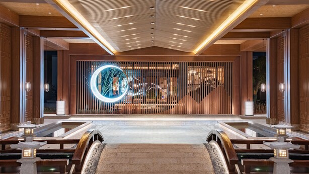 A modern interior with a central water feature, wooden paneling, and a unique circular light installation. - Holiday Inn Resort Yichun Mingyue Mountain (Yichun)
