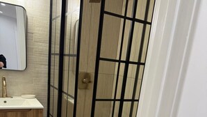 Un baño con cabina de ducha, lavamanos e inodoro.