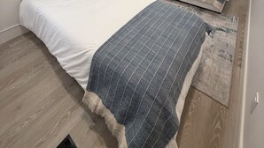 Un dormitorio con dos camas, una mesita de noche, un cuadro y un espejo.