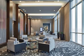 A hotel lobby with seating areas, a patterned carpet, and large windows. - Residence Inn Nashville Downtown (Nashville)